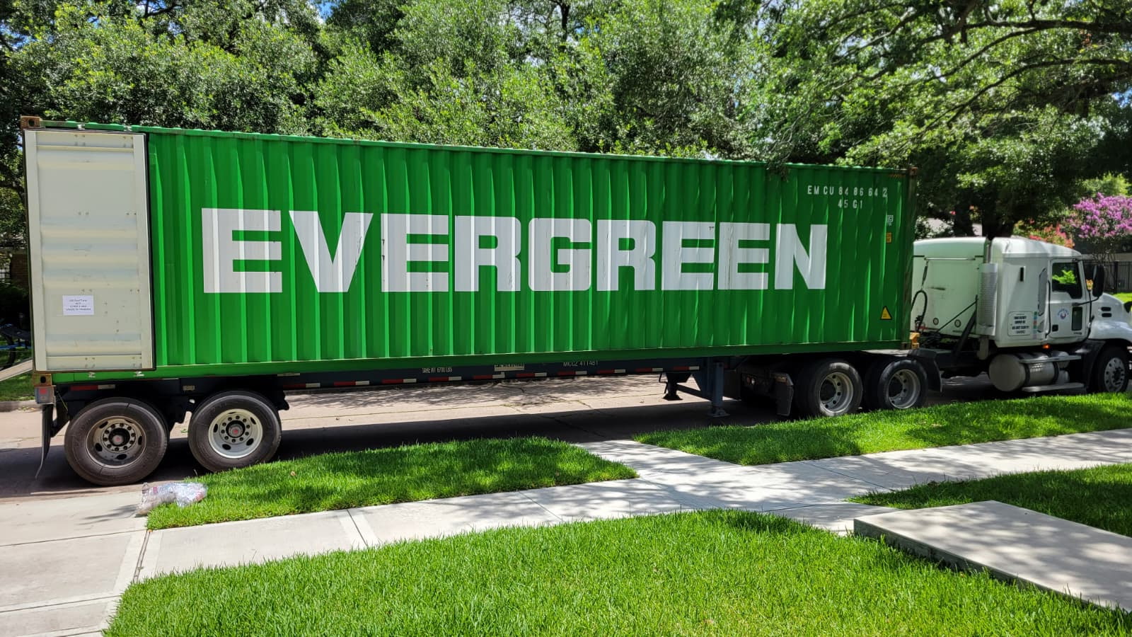 Loaded Evergreen shipping container on a Dimond Movers truck, ready for international departure