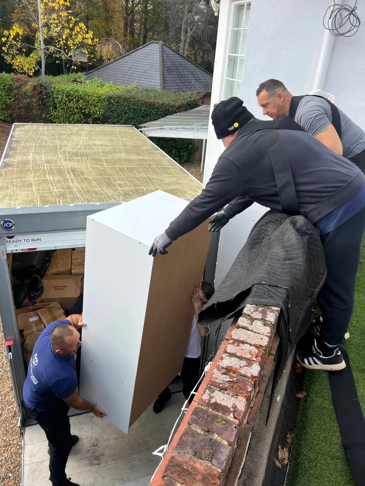 Removals team working together on a large item